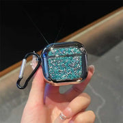 Turquoise glittery airpod case with carabiner held by a hand