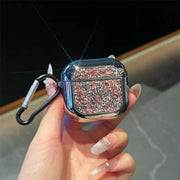 Hand holding a glittery pink airpods case with a carabiner