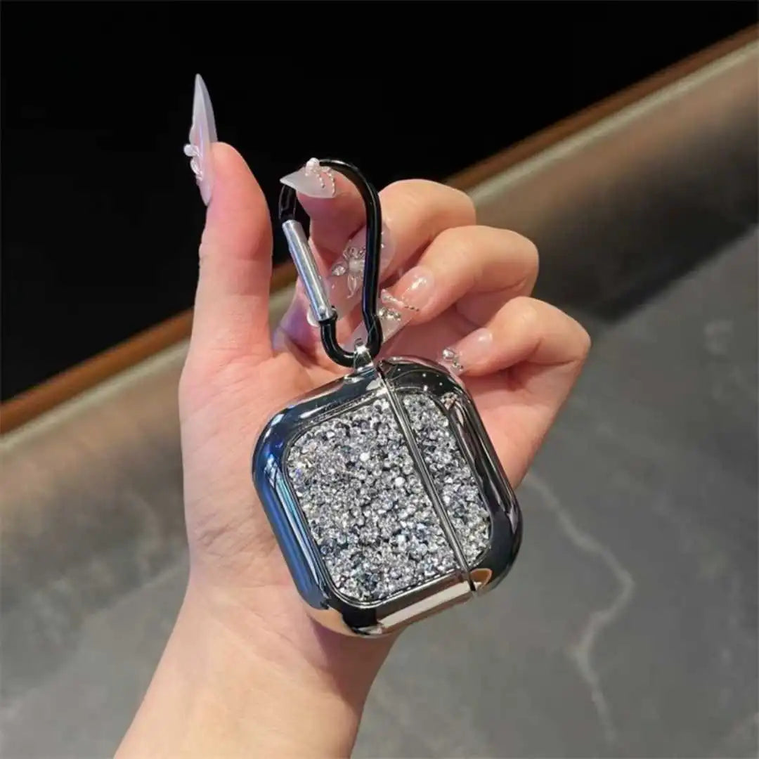 Hand holding a glittery case with a carabiner against a blurred background