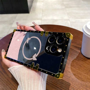 Person holding a phone case with decorative design on a wooden table