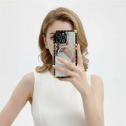 Person holding a phone with a mirror case against a white background