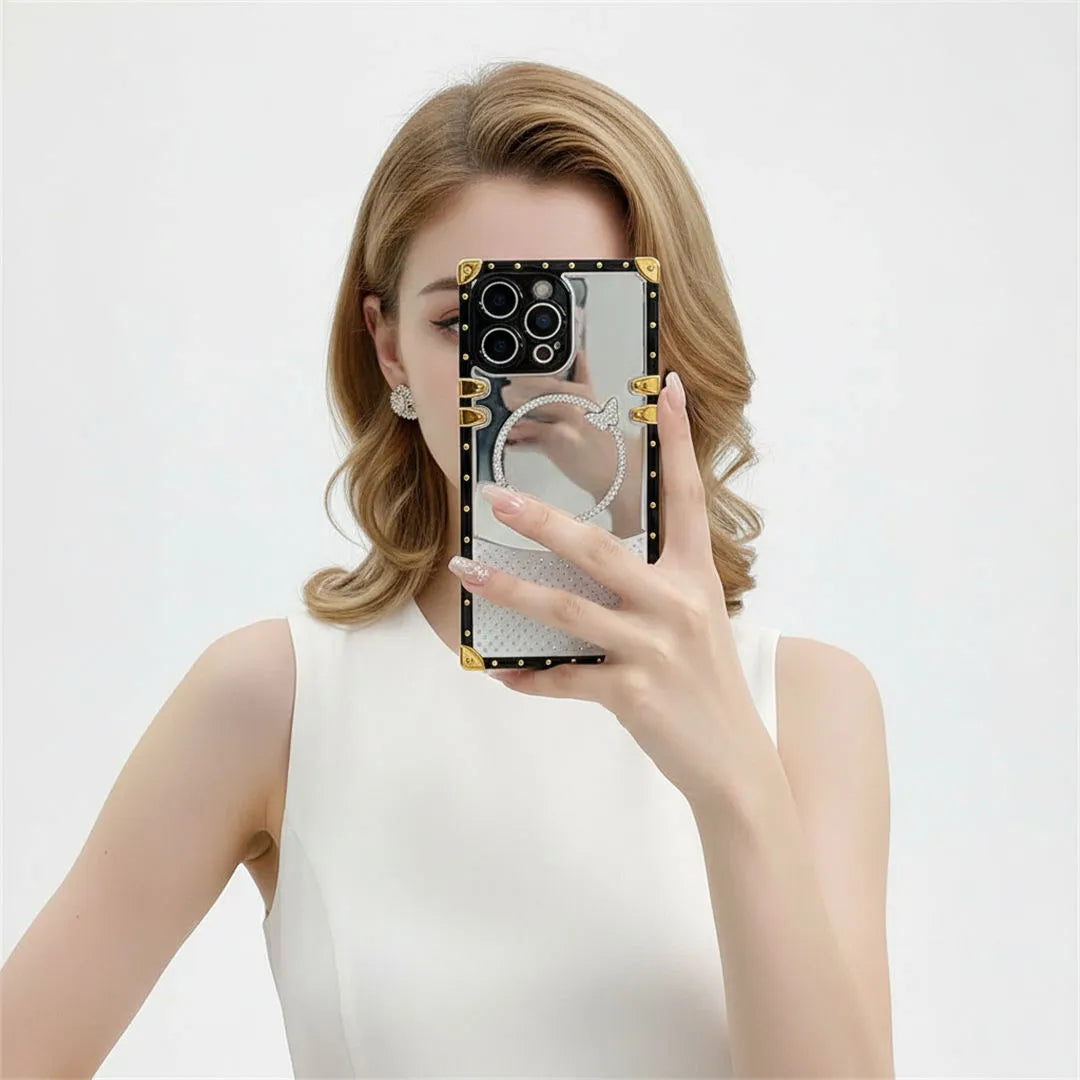Person holding a phone with a mirror case against a white background