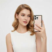 Woman holding a phone with a pink case against a white background