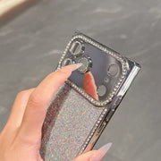 Hand holding a phone case with glittery design and rhinestone accents.