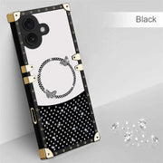 Black phone case with gold accents and white polka dots on a gray background
