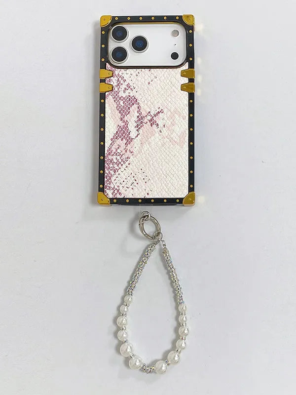 Phone case with pink glittery design and gold accents, featuring a beaded charm on a light gray background.