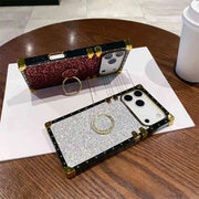 Two phone cases with rhinestone embellishments on a wooden table.