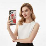 Woman holding a phone with a floral case against a white background