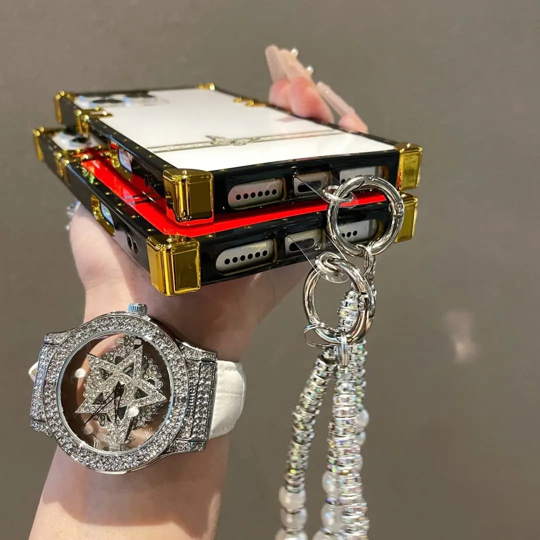 Phone case with intricate design held by a hand, featuring a star-shaped pendant.