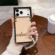 Phone case with decorative frame held by a hand on a wooden table.