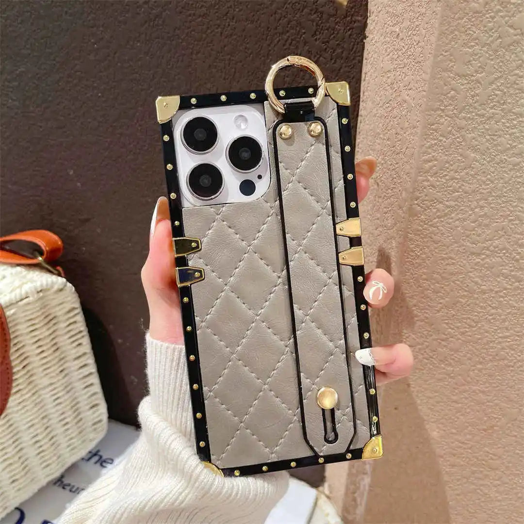 Gray Quilted phone case with hand strap held by a person against a neutral background