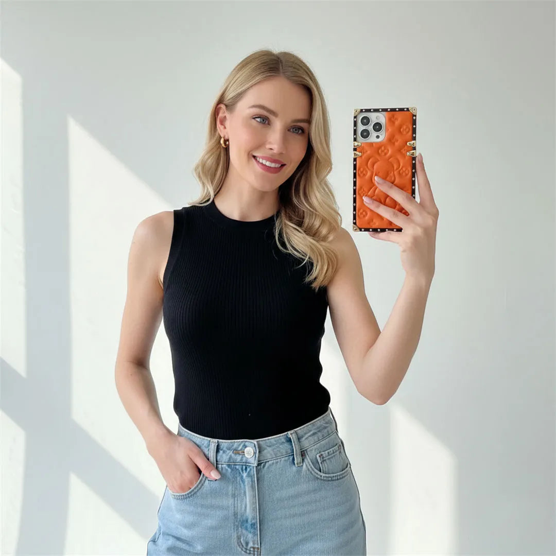 Woman taking a selfie with an orange square iphone case against a white background