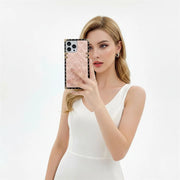 Woman holding a phone with a pink case against a white background