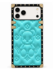 A protective phone case featuring a turquoise blue embossed teddy bear design with a black border and gold-tone hardware accents.