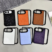 Six smartphone cases arranged in two rows on a light surface. The cases have black frames and back panels with a glittery texture, shown in black, orange, bronze, white, light blue, and purple.