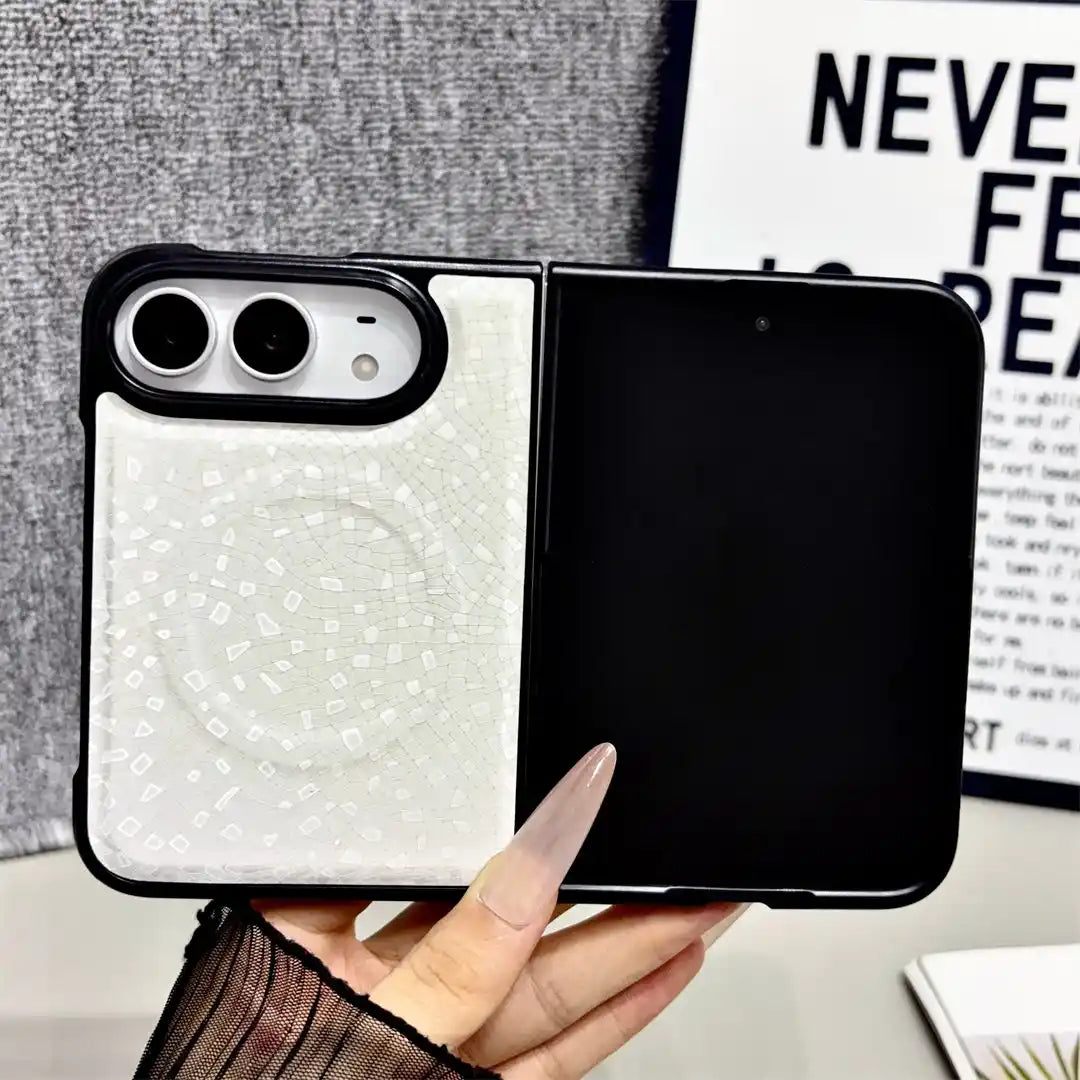 A hand holds a white split-design phone case with a textured circular magnetic ring on the back, shown against a gray textured background with a framed print.