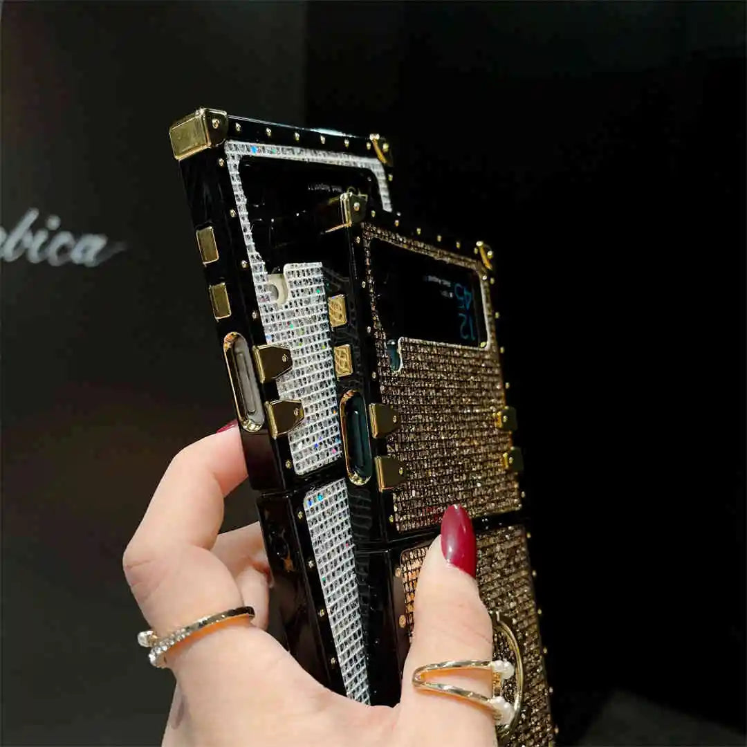 Hand holding a intricately designed phone case with rhinestones against a dark background