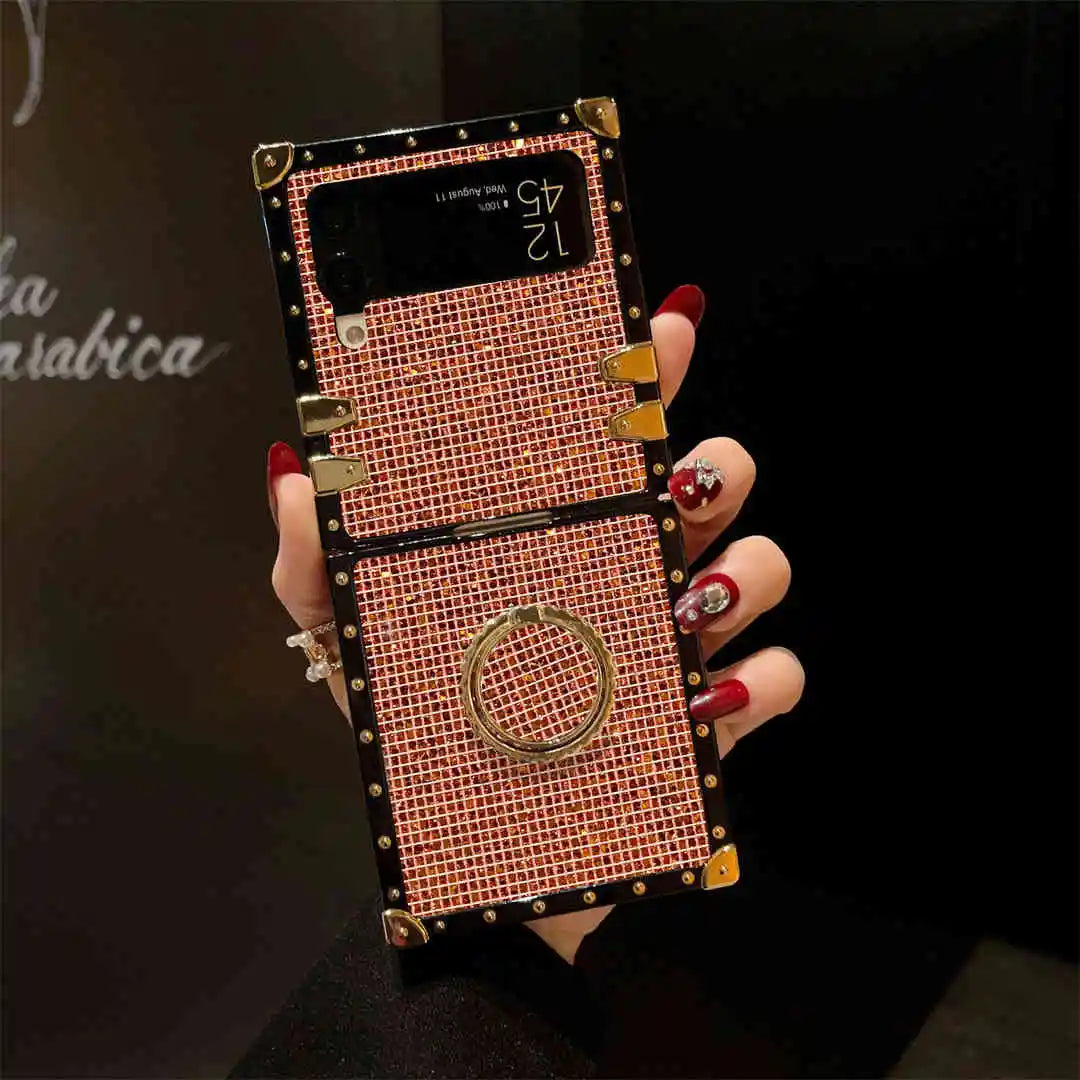 Hand holding a decorative phone case with intricate design and gold accents.