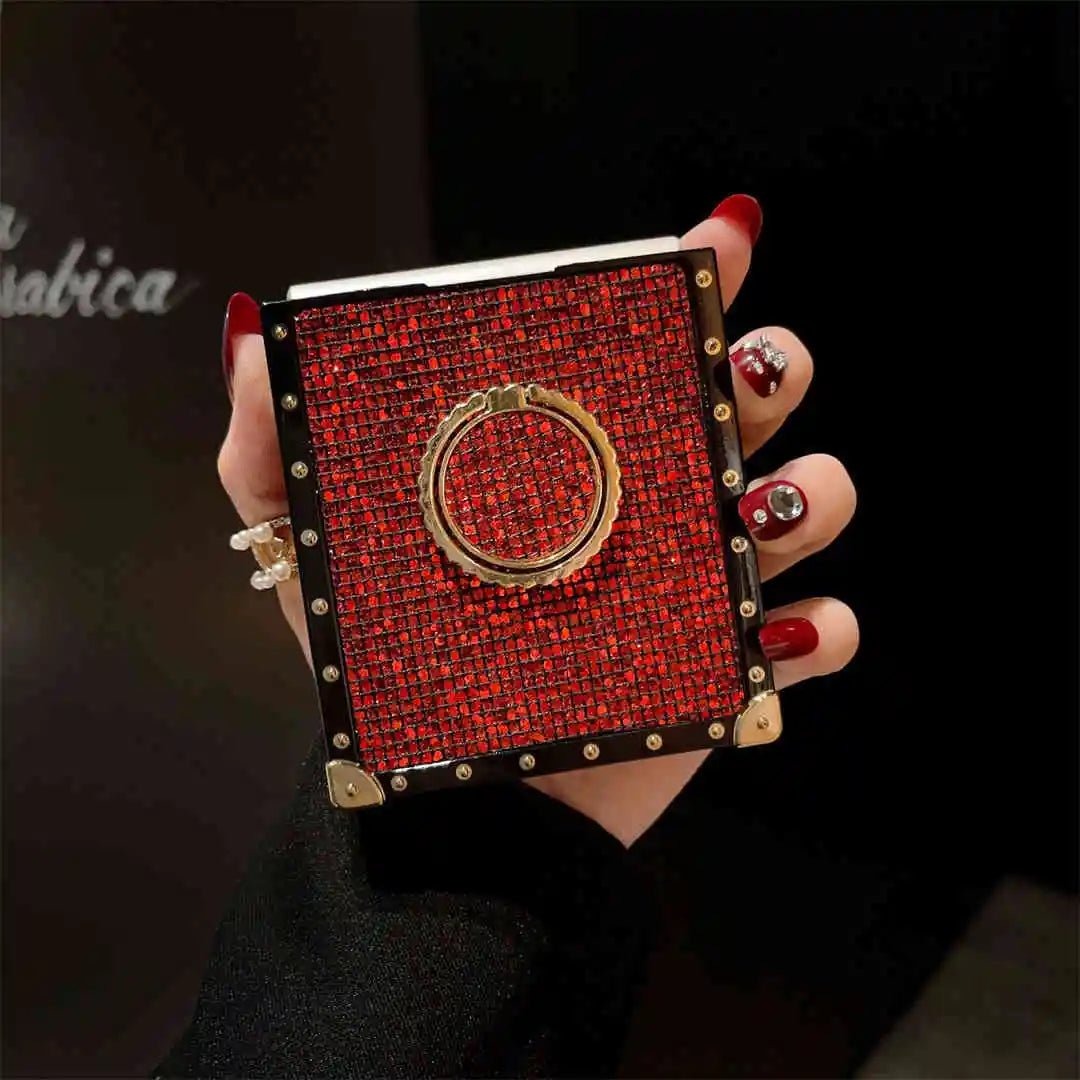 Hand holding a red foldable phone in red case with gold accents against a dark background