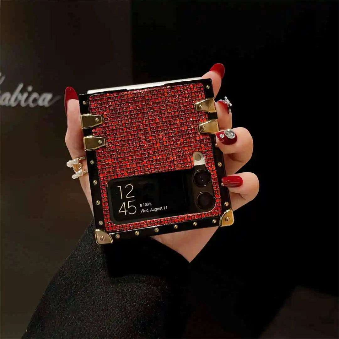 Hand holding a red and gold phone case with a black background