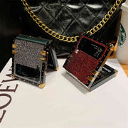 Two stylish phone cases, one black with gold accents and one red with gold accents, on a white surface.