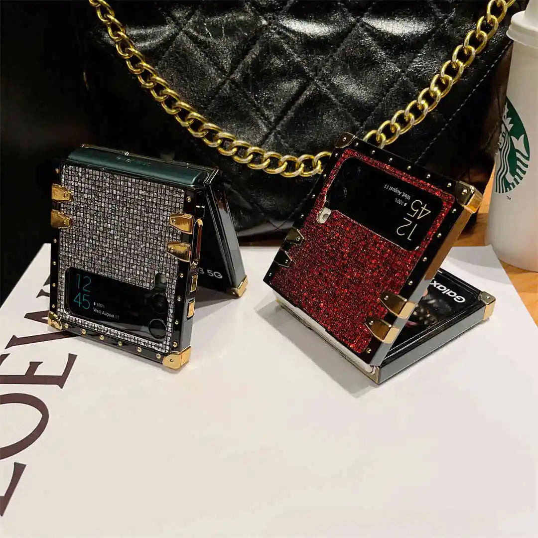 Two stylish phone cases, one black with gold accents and one red with gold accents, on a white surface.
