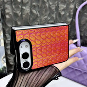 Orange Prism Scale Duo case held horizontally, showing iridescent scale texture