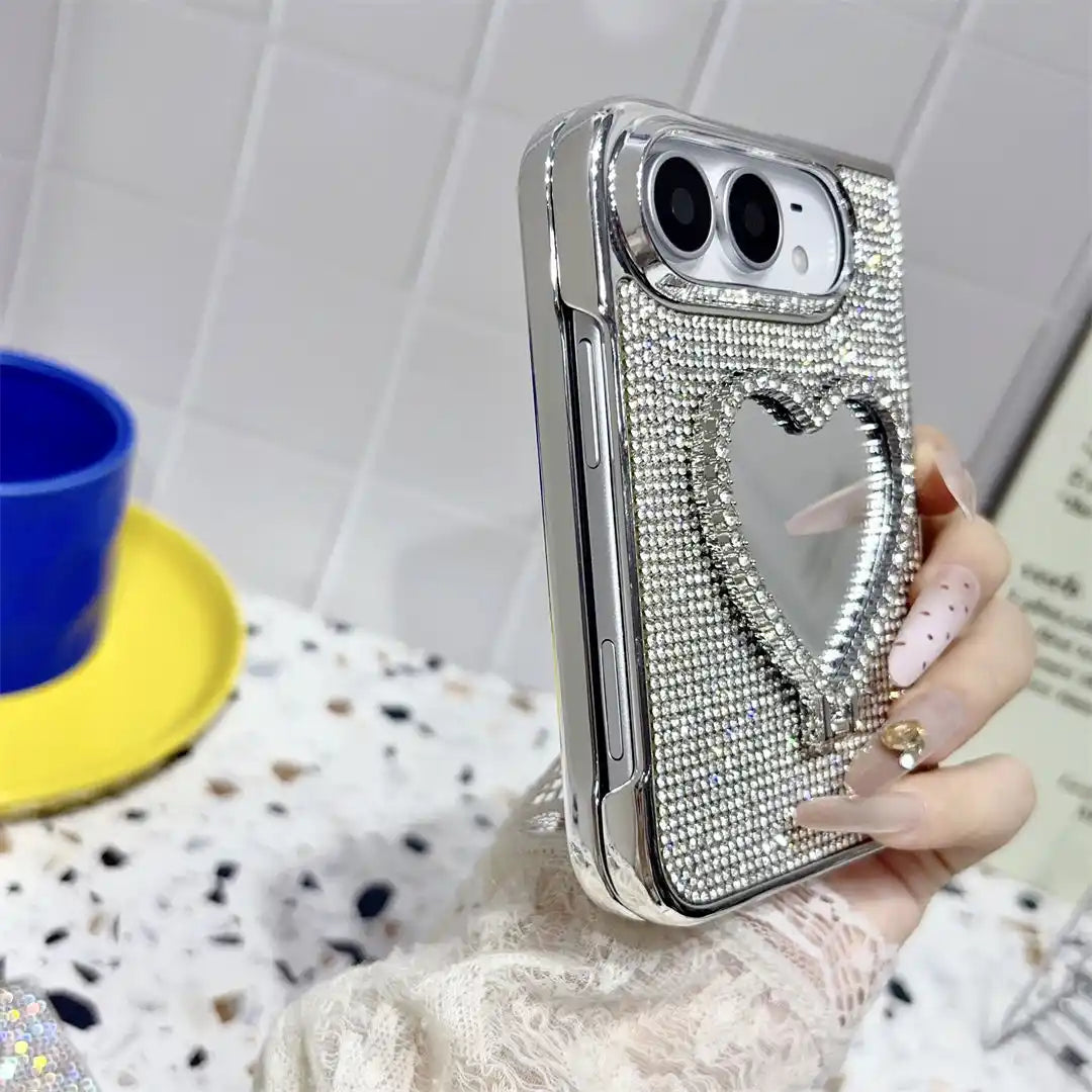Hand holding the folded silver Crystal Heart Duo case, showing rhinestone trim and heart-shaped mirror