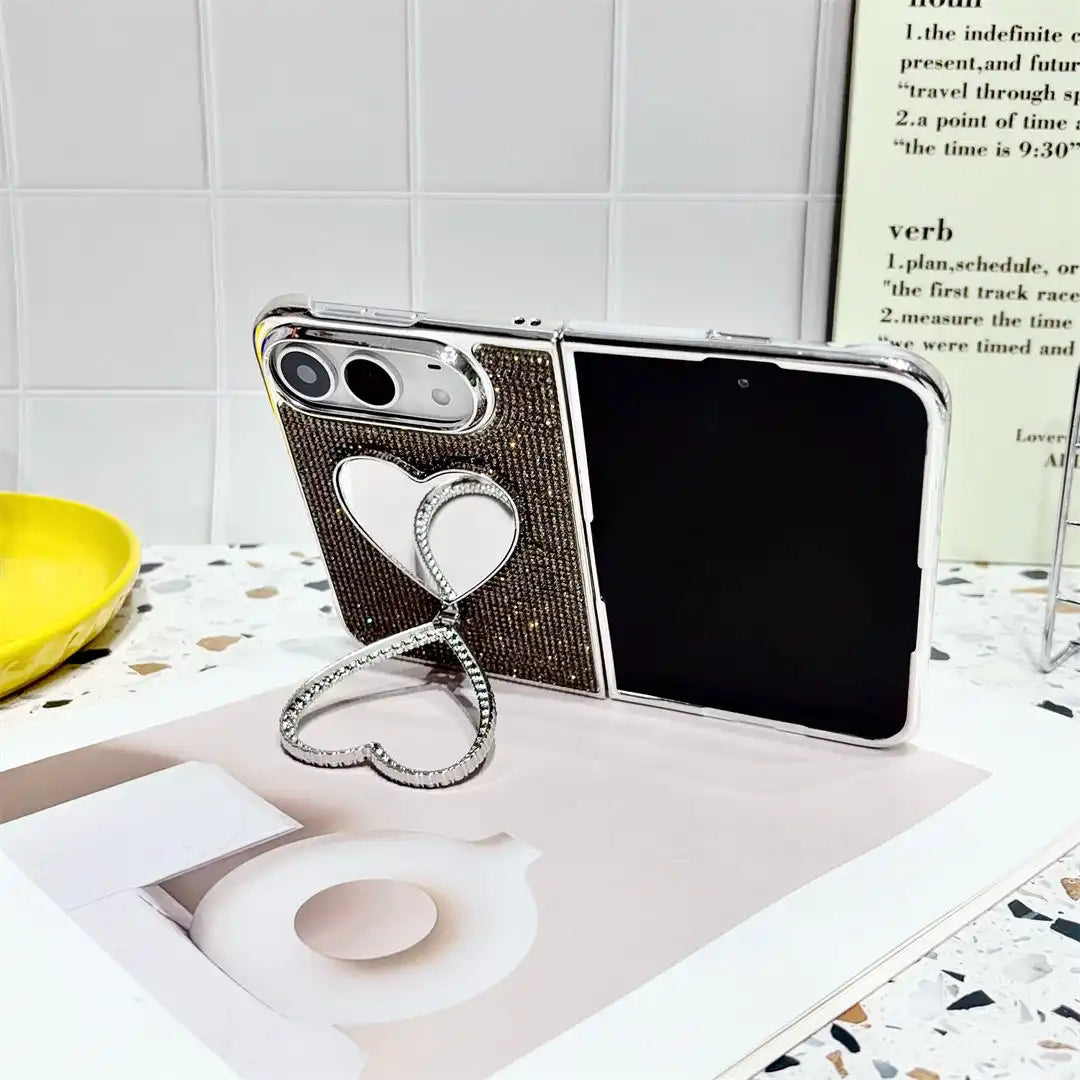 Open iPhone Duo in the black Crystal Heart Duo case resting on a book with heart-shaped stand extended