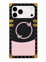 A protective phone case with a black and pink design, featuring a rhinestone-embellished circular motif with butterfly details and gold-tone corner protectors and studs, shown on a white background.