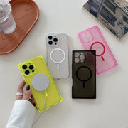 Four MagSafe-compatible phone cases in different colors (yellow-green, clear, dark brown, and pink) are displayed on a white surface, with one case being held by a hand wearing a silver ring.