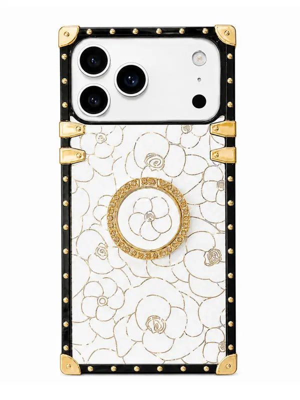 A luxury phone case featuring a white background with an elegant gold floral pattern, framed by a black border adorned with gold studs and corner protectors. A circular gold pop socket is attached to the center back.