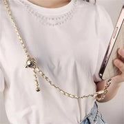 Gold chain phone holder draped over a white shirt with a plain background