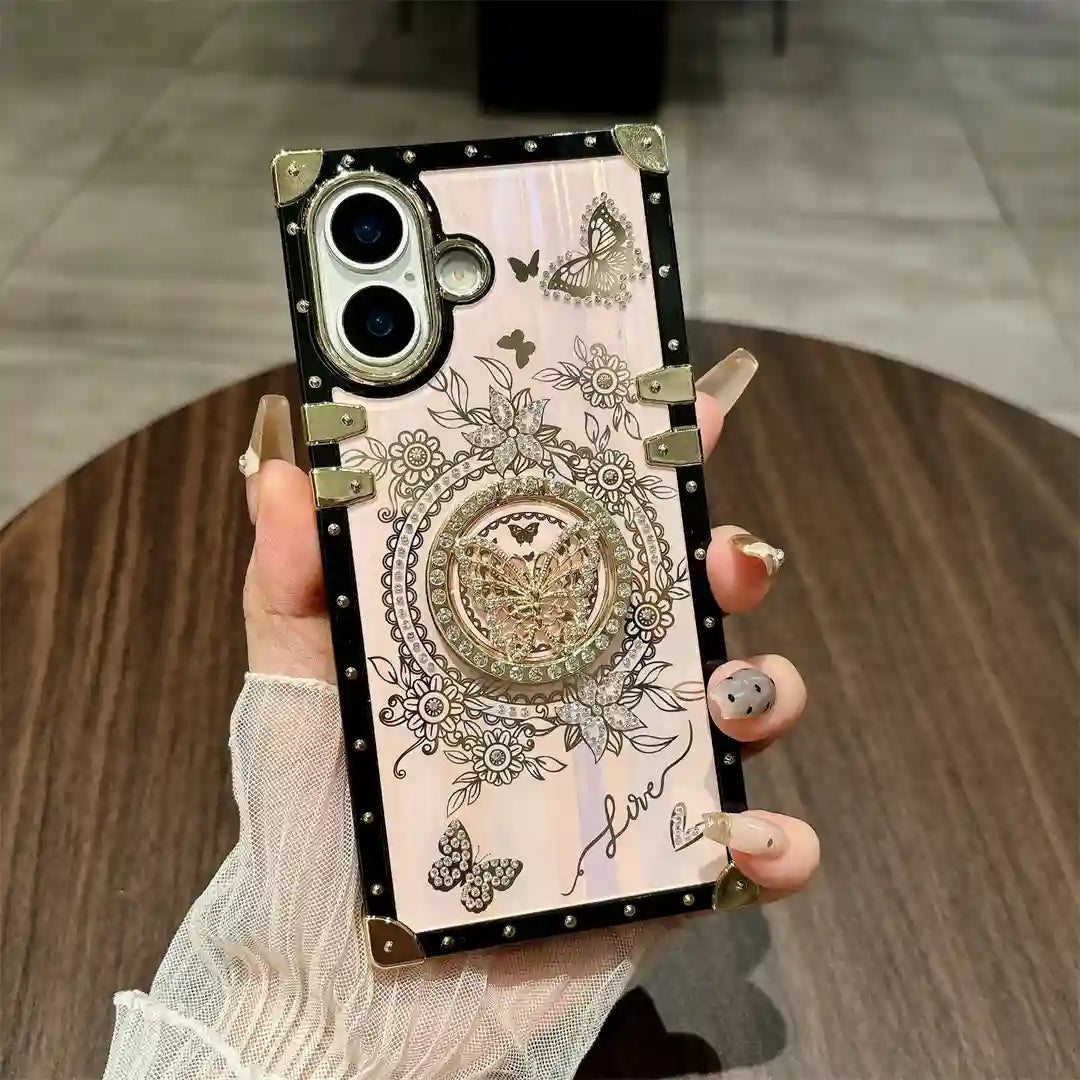Hand holding the white Aurora Butterfly Trunk iPhone case with butterfly decoration and gold-tone trim