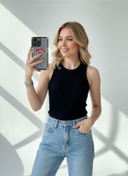 Woman holding a phone case with a black and white pattern against a white background