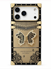 A luxury-style phone case designed like a vintage suitcase, featuring a black and gold color scheme with a 3D rhinestone-embellished butterfly on the back. The case has gold-tone metal corners and rivets, and the text 'LIMITED EDITION BUTTERFLY' is printed near the bottom.