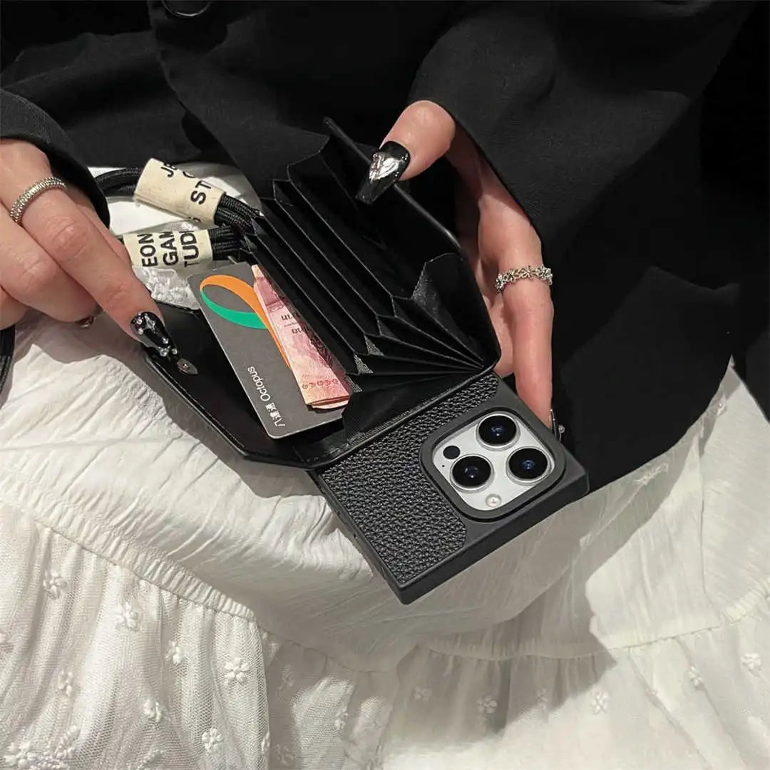 Person holding a black wallet case with cards and money, wearing a white dress.