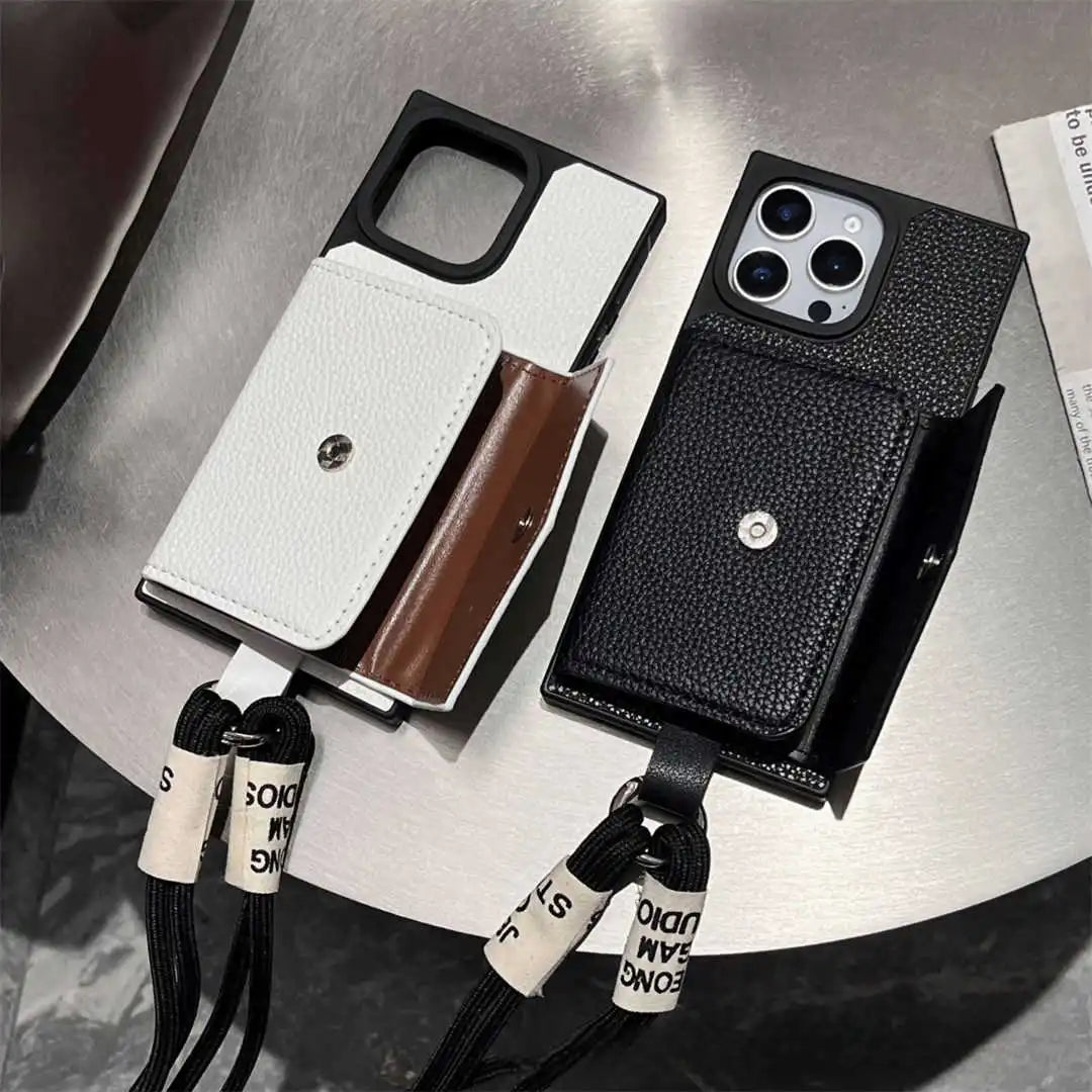 Two wallet phone cases with lanyards on a metallic surface