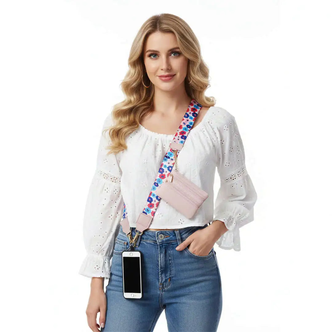 Woman wearing a white blouse, blue jeans, and a pink crossbody phone strap with a colorful strap.