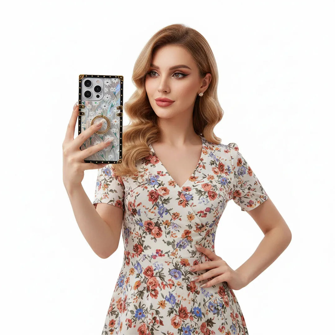 Woman in a floral dress holding a phone with a decorative case on a white background