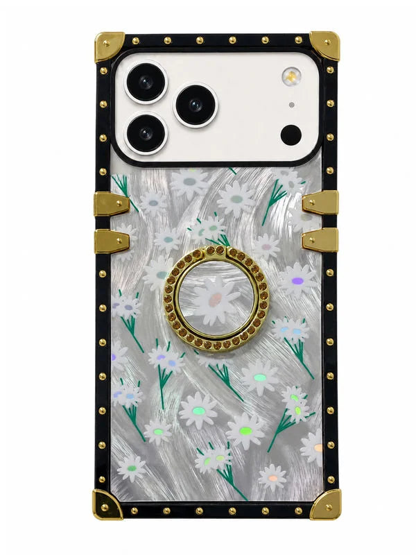 A protective phone case with a clear back decorated with a white daisy and green stem pattern over a silver glitter background. It features a gold circular pop socket in the center, a black border, and gold metal corner guards and rivets.