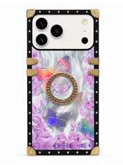 A protective phone case with a black border, gold-tone metal corner guards and latches, and a back panel decorated with purple roses and colorful butterflies on a gray textured background.