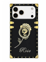 A black phone case with gold-tone metal corner protectors and rivets, featuring a gold rose illustration in a circular frame and the word 'Rose' in rhinestone-style script near the bottom.