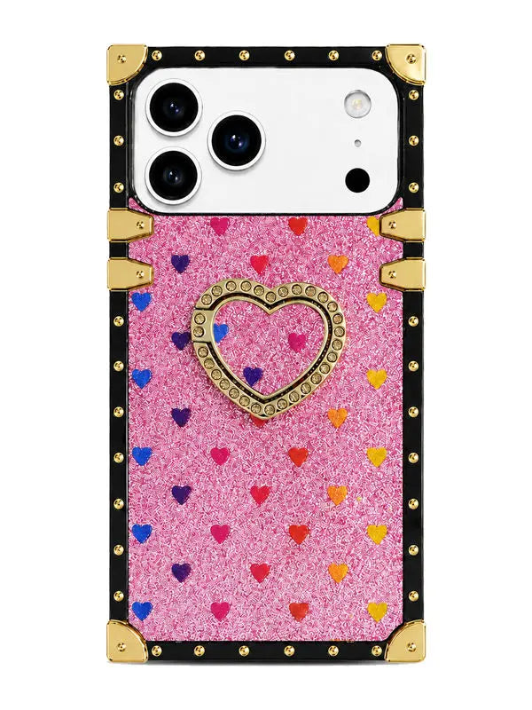 A protective phone case with a pink glitter background, decorated with small colorful hearts and a central gold heart frame. The case features a black border with gold metallic studs and corner protectors, shown on a white phone against a plain white background.