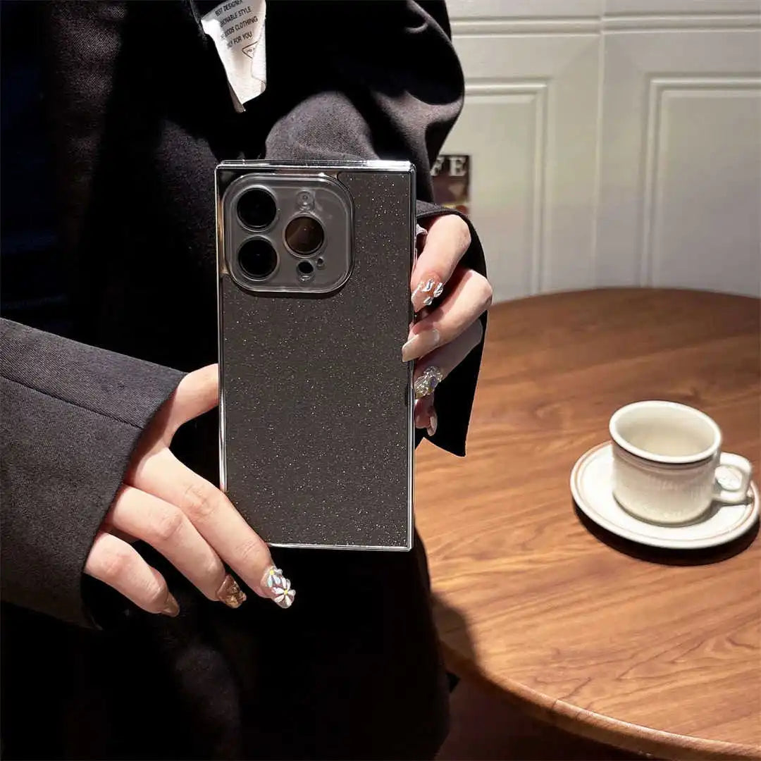 Person holding a smartphone with a reflective case in a casual setting