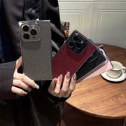 Person holding two phone cases with a blurred background