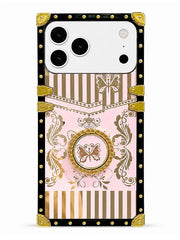 A protective phone case with a luxury fashion-inspired design, featuring a light pink background with gold and brown stripes, butterfly motifs, and ornate baroque-style flourishes. The case is framed by a black border decorated with gold rivets and reinforced with gold corner protectors.