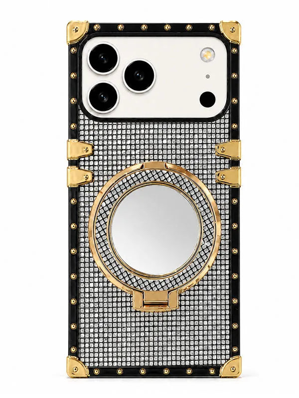 A luxury-style phone case with a black and silver rhinestone grid pattern, gold-tone corner protectors, rivets, and a built-in circular mirror on the back, shown on a white phone against a plain white background.
