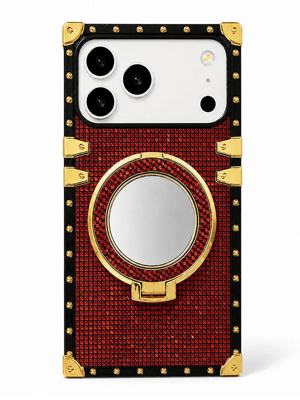 A luxury-style phone case with a red rhinestone-embossed body, black trim, gold corner protectors and hardware, and a circular mirror integrated into the center ring stand, shown on a white background.