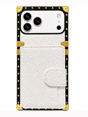 A white textured faux-leather phone case with a snap-button flap pocket, featuring a black border with gold-tone metal studs and corner protectors, shown on a white background.